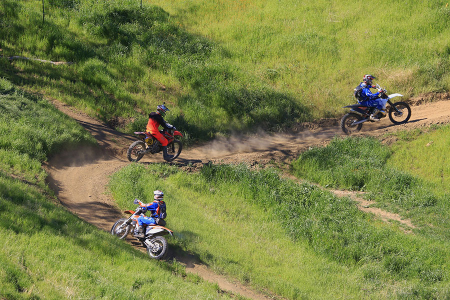Motorcyclists Driving up a Trail