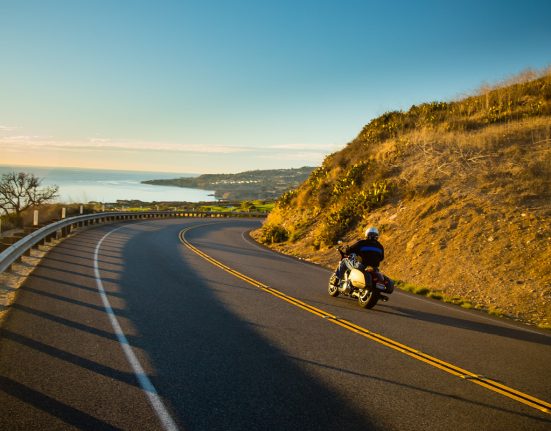 Motorcycle driving down windy scenic road