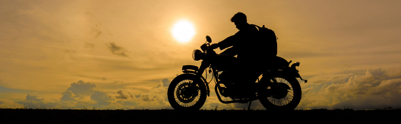 Motorcyclists silhouette against the setting sun