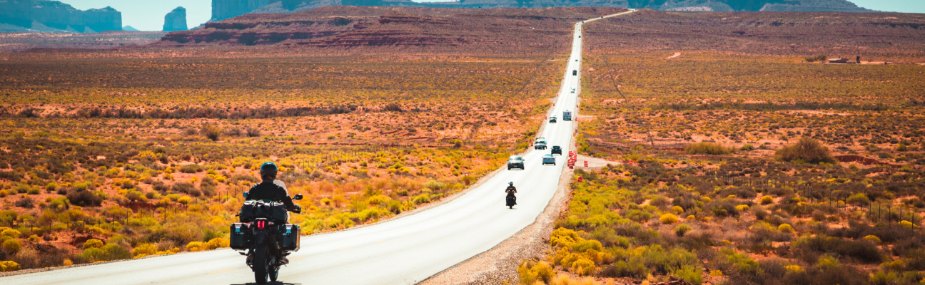 Motorcycles driving down road in the desert