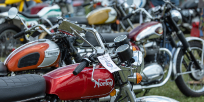 zoomed up image of red motorcycle amongst a crowd of motorcycles